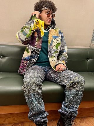 Trendy man with silk scarf wrapped around arm in summer yellow pattern with floral details